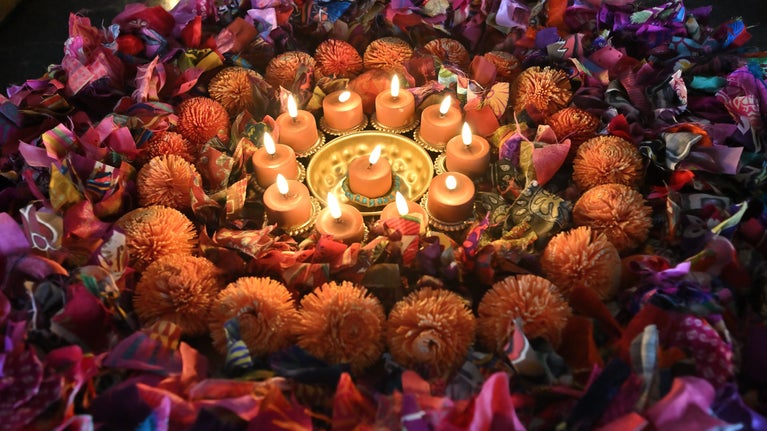 Diyas amongst colourful wreaths make up a Diwali display